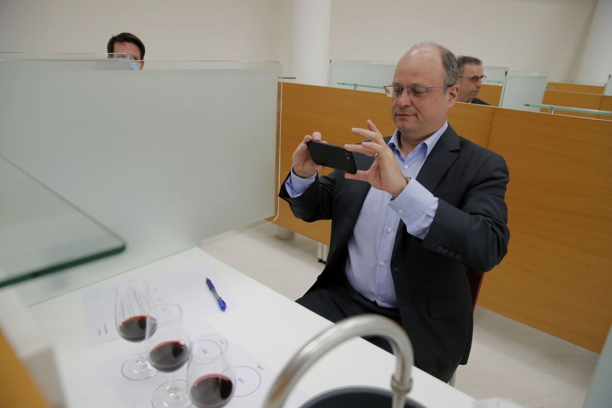 Chief Operating Officer of French National Centre for Space Studies (CNES) Lionel Suchet takes a pictures of glasses of red wine during a tasting of regular bottles and others that spent a year orbiting the world in the International Space Station